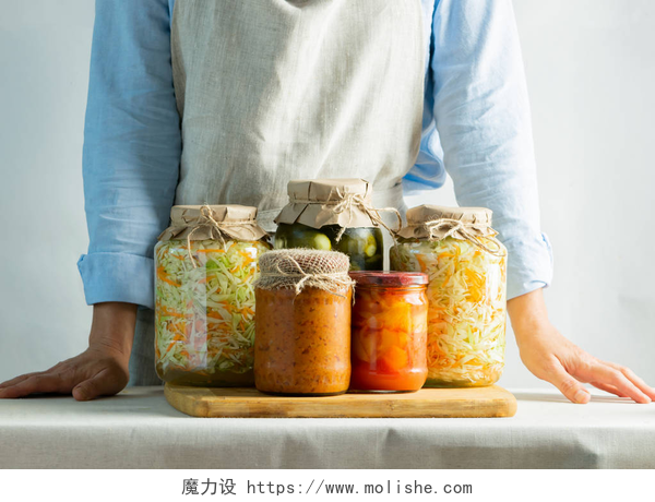 桌子上的腌制食品发酵或罐装蔬菜，不同的西葫芦，胡萝卜，酸菜，黄瓜在罐子上站在盐对